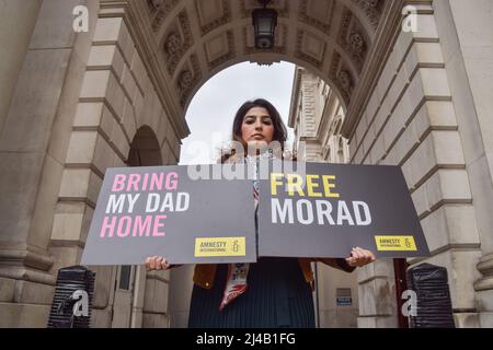 London, Großbritannien. 13. April 2022. Roxanne Tahbaz hält während des Protestes Plakate mit dem Titel „Bring My Dad Home“ und „Free Morad“. Roxanne Tahbaz veranstaltete einen Protest mit Amnesty International vor dem Außen-, Commonwealth- und Entwicklungsbüro in Westminster und forderte die britische Regierung auf, ihre Bemühungen zu verstärken, ihren Vater Morad Tahbaz nach Hause zu holen. Morad, ein Naturschützer und US- und britischer Staatsbürger mit iranischem Familienhintergrund, ist seit mehr als vier Jahren willkürlich im Iran inhaftiert. (Foto: Vuk Valcic/SOPA Images/Sipa USA) Quelle: SIPA USA/Alamy Live News Stockfoto