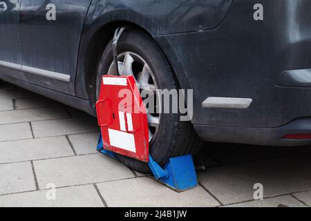 Auto Radklemme gesperrt illegal geparkte Autos Autorad durch Radsperre wegen illegaler Parkverletzung blockiert. Das Autorad Wurde Mit Gesperrt Stockfoto