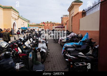 MARRAKESCH, MAROKKO - 21. NOVEMBER; 2018 Motorroller und Fahrräder vor der Medina-Mauer geparkt Stockfoto