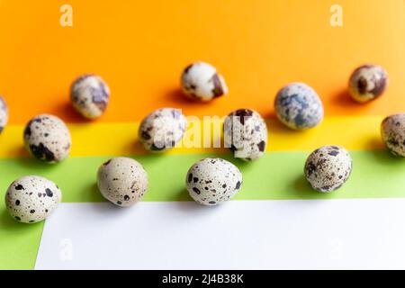 Kleine gefleckte Wachteleier, verstreut auf beigefarbenem Tuch und Bouquet von getrockneten blauen Gypsophila-Blüten. Stockfoto