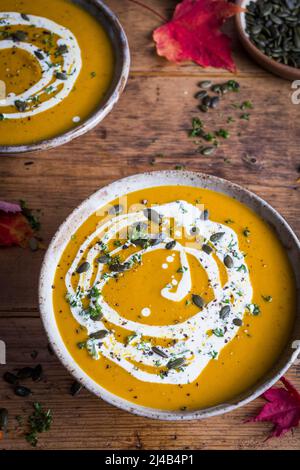 Kürbissuppe mit einem Strudel von Creme und Kürbiskernen gekrönt Stockfoto