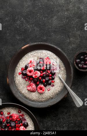 Chia-Samenpudding, gekrönt mit Himbeeren, Blaubeeren und Granatapfelkernen Stockfoto