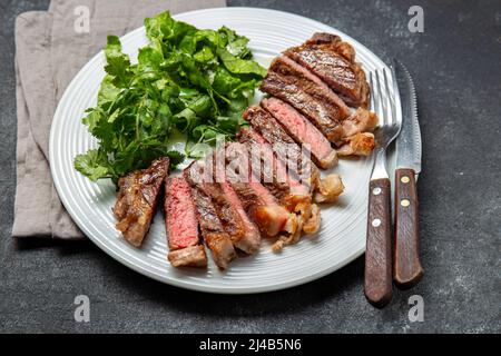 Gegrilltes Steak in Scheiben geschnitten auf einem weißen Teller Stockfoto
