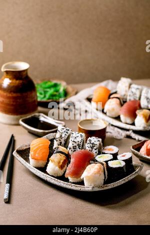 Sushi-Brötchen für zwei Personen. Traditionelles japanisches Sushi und Brötchen mit frischem Lachs, Thunfisch, Aal und Garnelen auf Reis. Auf Tellern mit Sojasauce A servieren Stockfoto