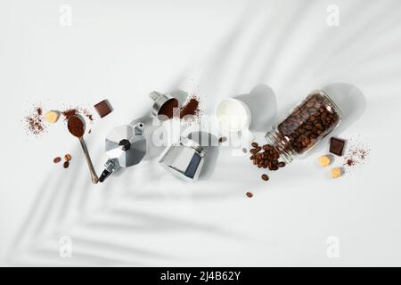 Kaffeekomposition auf hellgrauem Hintergrund, Palmblatt-Schatten, flache Lay, Draufsicht, minimalistisches Konzept Stockfoto