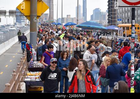 Touristen kommen wieder nach New York City. Am 13. April 2022 läuft eine große Menschenmenge über die Brooklyn Bridge in New York City. Stockfoto