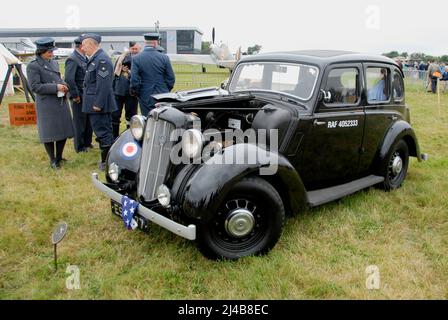 Das Morris 12-Fahrzeug mit RAF-Markierungen und geöffneter Motorhaube wird auf einer Flugausstellung in Biggin Hill, Kent, England, mit Kundendienstmitarbeitern ausgestellt Stockfoto