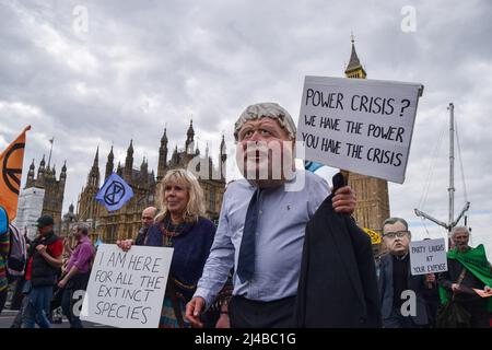 London, Großbritannien, 13.. April 2022. Ein Protestler, der eine Boris Johnson Maske auf der Westminster Bridge trägt. Extinction Rebellion Demonstranten marschierten durch das Zentrum Londons und forderten, dass die Regierung gegen die ökologische und Klimakrise handelt. Kredit: Vuk Valcic/Alamy Live Nachrichten Stockfoto