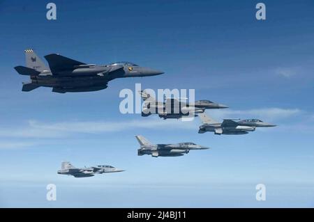 Eine Formation von Flugzeugen, darunter ein Royal Singapore Air Force F-15E Strike Eagle, oben links, USA, Royal Thai und Royal Singapore Air Force F-16 gegen Falken, Mitte, und ein RSAF JAS 39 GRIPEN, unten links, fliegen in Formation während Cope Tiger 2022 auf dem Korat Royal Thai Air Base, Thailand. Cope Tiger ist eine jährliche multilaterale Luftübung, die darauf abzielt, die Kampfbereitschaft und Interoperabilität zwischen der Republik Singapur, den Royal Thai und den US-Luftstreitkräften zu verbessern und gleichzeitig die militärischen Beziehungen der drei Nationen zu verbessern. (USA Foto der Air Force) Stockfoto