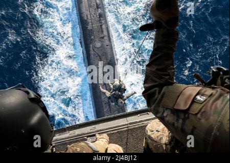 Flugingenieure der US-Luftwaffe, die dem Special Operations Wing von 352d zugewiesen sind, unterstützen die Naval Special Warfare Task Unit-Europe beim Heben von einem CV-22B Fischadler an das Deck eines U-Boots, das Naval Forces Europe (NAVEUR) im östlichen Mittelmeer zugewiesen wurde, am 16. Dezember 2021. Diese gemeinsame Schulung ermöglicht es den Sondereinsatzkräften und den maritimen Vermögenswerten für die NAVEUR-Flotte zusammenzukommen und die Bereitschaft im gesamten Theater zu verbessern. Dieses erste Mal wurde die Fähigkeit verbessert, SOF-Flugzeuge zu verwenden, was schnelle Infiltrations- und Nachversorgungsoptionen für ein Spektrum von SOF-Missionen bietet. (USA Luftwaffe Foto Stockfoto