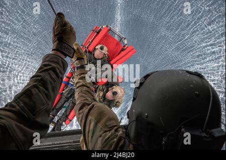 Ein Flugingenieur der US-Luftwaffe, der dem Special Operations Wing von 352d zugewiesen wurde, unterstützt die Naval Special Warfare Task Unit-Europe mit einem simulierten Mann-über-Bord-Szenario, von einem Fischadler CV-22B neben einem U-Boot, das Naval Forces Europe (NAVEUR) im östlichen Mittelmeer zugewiesen wurde, 18. Dezember 2021. Diese gemeinsame Schulung ermöglicht es den Sondereinsatzkräften und den maritimen Vermögenswerten für die NAVEUR-Flotte zusammenzukommen und die Bereitschaft im gesamten Theater zu verbessern. Dieses erste Mal wurde die Fähigkeit verbessert, SOF-Flugzeuge zu verwenden, was schnelle Infiltrations- und Nachversorgungsoptionen für ein Spektrum von SOF-Missionen bietet Stockfoto