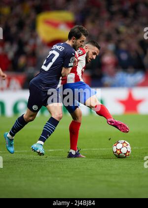 Madrid, Spanien. 13. April 2022. Koke (R) von Atletico de Madrid steht mit Bernado Silva von Manchester City während eines UEFA Champions League-Viertelfinalmatches in der zweiten Etappe zwischen Atletico de Madrid (Spanien) und dem Manchester City FC of England im Wanda Metropolitano Stadium in Madrid, Spanien, am 13. April 2022, gegenüber. Quelle: Meng Dingbo/Xinhua/Alamy Live News Stockfoto