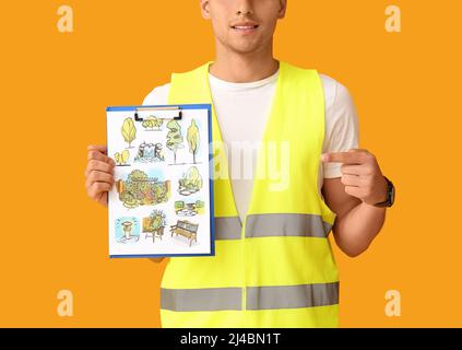 Junger männlicher Landschaftsdesigner mit neuem Projekt auf farbigem Hintergrund Stockfoto