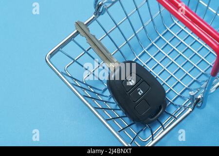 Autoschlüssel in einem Korb auf blauem Hintergrund. Stockfoto