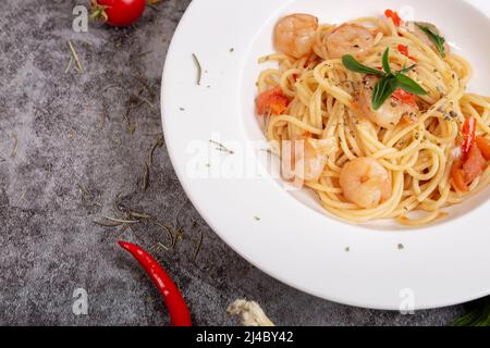 Leckere Garnelen-Spaghetti auf einem Zementtisch Stockfoto