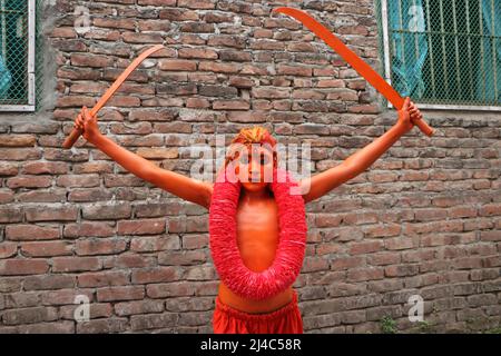 Non Exclusive: MUNSHIGANJ, BANGLADESH - APR 14, 2022: Ein junger Hindu-Anhänger mit seiner in roter Farbe gemalten corp nimmt an einer Prozession Teil Stockfoto