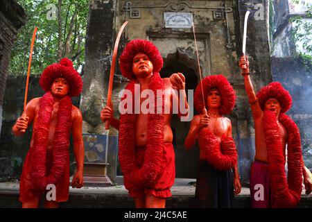 Non Exclusive: MUNSHIGANJ, BANGLADESH - APR 14, 2022: Hinduistische Anhänger mit ihrem rot gemalten corp nehmen an einer Prozession mit Schwor Teil Stockfoto