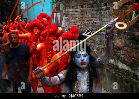Non Exclusive: MUNSHIGANJ, BANGLADESH - APR 14, 2022: Hinduistische Anhänger mit ihrem rot gemalten corp nehmen an einer Prozession mit Schwor Teil Stockfoto