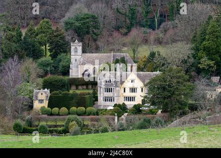 Grade I gelistetes Tudor Owlpen Manor mit 19. Jahrhundert Kirche des Heiligen Kreuzes hinter. Uley, Gloucestershire, Großbritannien Stockfoto