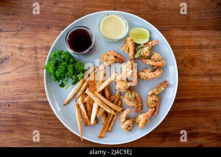 Garnelen-Tempura und Salat aus frischem Gemüse Nahaufnahme auf einer Platte auf einem Tisch. horizontale Ansicht von oben Stockfoto