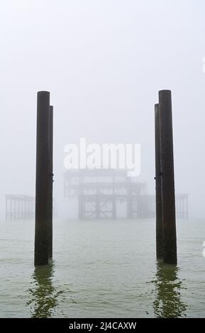 Brighton UK 14. April 2022 - der West Pier in Brighton ist heute früh in Nebel gehüllt, da für das Osterwochenende warmes, sonniges Wetter prognostiziert wird : Credit Simon Dack / Alamy Live News Stockfoto