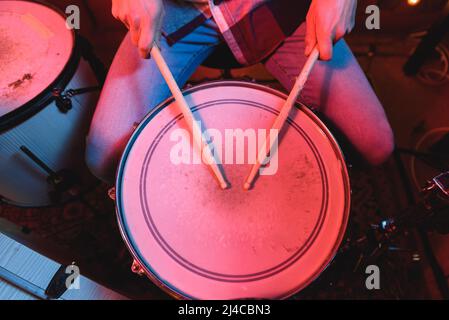 Von oben auf der talentierten Crop anonymen männlichen Musiker Schlagzeug mit Drums spielen, während der Durchführung Song auf der Bühne während Live-Konzert Stockfoto