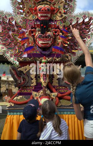 Frauen- und Kindertouristen achten auf eine traditionelle, skulpturale Kunst aus Reismehl als Opfergabe für spirituelle Zeremonien in Bedugul, Tabanan, Bali, Indonesien. Stockfoto