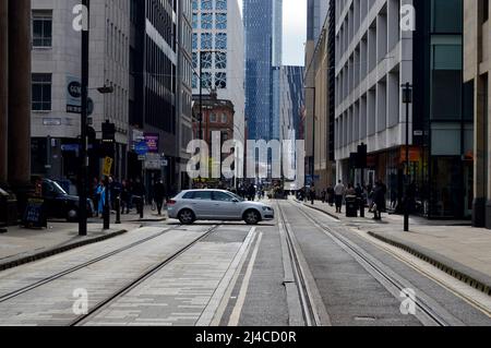 MANCHESTER. GREATER MANCHESTER. ENGLAND. 04-10-22. Mosley Street im Stadtzentrum mit Blick auf den Petersplatz. Ein Auto überquert die Straßenbahnschienen. Stockfoto