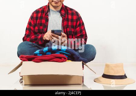 Mann, der eine Kiste mit gebrauchter Kleidung in der Hand hält Stockfoto