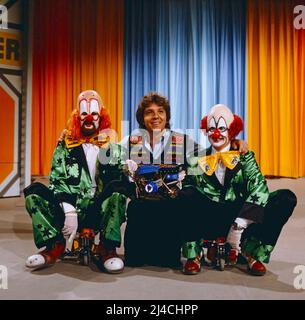 1, 2 oder 3, ZDF Quizshow für Kinder, moderiert von Michel Schanze, auf dem Bild mit zwei Clowns, Deutschland, 1981. 1, 2 oder 3, TV-Quizshow für Kinder, präsentiert von Michael Schanze, auf dem Foto mit zwei Clowns, Deutschland, 1981. Stockfoto