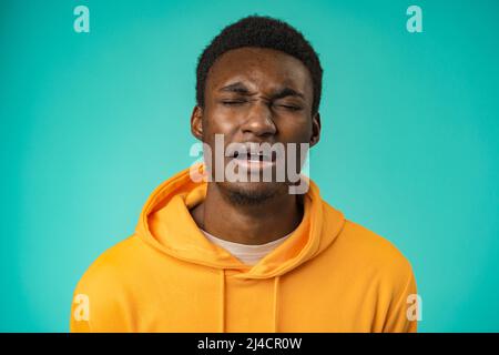Porträt eines jungen, gutaussehenden Afro-amerikaners, der im Studio traurigerweise die Kamera anschaut Stockfoto