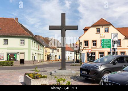 Kruzifix auf dem Marktplatz, Hoyerswerdaer Straße im Hintergrund, Wittichenau, Sachsen, Deutschland Stockfoto