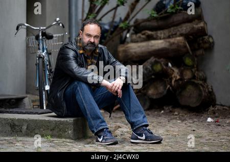 Berlin, Deutschland. 11. April 2022. Schauspieler Tom Keune sitzt auf einer Treppe in einem Hinterhof während eines Spaziergangs durch Neukölln. Quelle: Monika Skolimowska/dpa/Alamy Live News Stockfoto