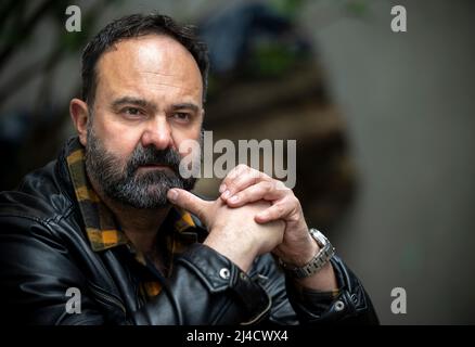 Berlin, Deutschland. 11. April 2022. Der Schauspieler Tom Keune sitzt während eines Spaziergangs durch Neukölln in einem Hinterhof. Quelle: Monika Skolimowska/dpa/Alamy Live News Stockfoto