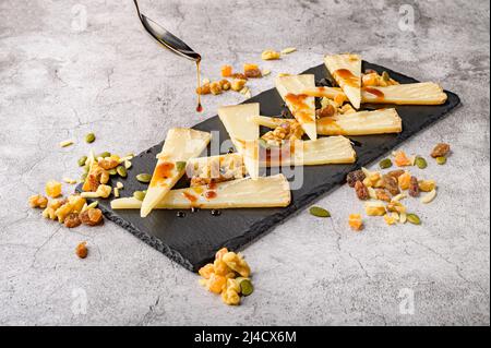 Käse mit Honig auf dem Schneidebrett Stockfoto