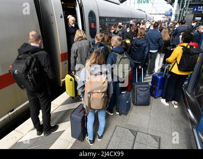 Köln, Deutschland. 14. April 2022. Reisende steigen in einen Zug der Deutschen Bahn ein. Kurz vor Karfreitag setzt die Deutsche Bahn weitere Züge ein, um den erwarteten Ansturm der Osterreisen besser zu bewältigen. Quelle: Roberto Pfeil/dpa/Alamy Live News Stockfoto