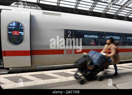 Köln, Deutschland. 14. April 2022. Eine Fahrgast kommt mit ihrem Gepäck am Hauptbahnhof in einen Zug der Deutschen Bahn. Kurz vor Karfreitag setzt die Deutsche Bahn weitere Züge ein, um den erwarteten Ansturm der Osterreisen besser zu bewältigen. Quelle: Roberto Pfeil/dpa/Alamy Live News Stockfoto