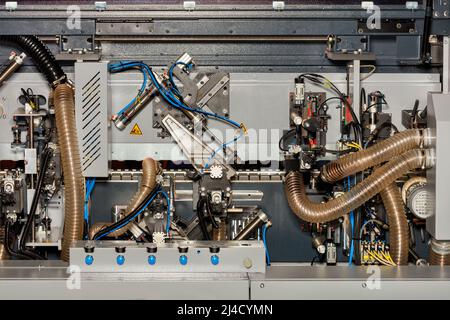 Fragment von internen Kontrollmechanismen und Spanabsaugsystemen in einer modernen Holzbearbeitungsmaschine mit Luftabsaugung. Stockfoto