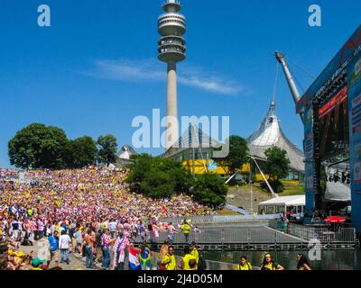 Fußballfans in der Münchner Fanzone im Olympiapark (Olympiapark) schauen sich das Spiel während der FIFA Fußball-Weltmeisterschaft 2006 auf der großen Leinwand an. 18. Juni 2006, München, Deutschland, Europa. In 12 Gaststädten in ganz Deutschland fanden Fanzonen mit großen Bildschirmen für die öffentliche Betrachtung von Spielen statt, die Millionen Besucher anlockte. Stockfoto