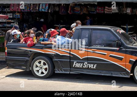 Thailand, Transport von Menschen. Überladenes Fahrzeug. Pickup-LKW voll beladen mit Menschen fahren im Heck. Thailand Südostasien Stockfoto