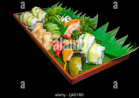 Gestanztes vegetarisches Sushi verschiedener Art auf schwarz isoliert. Stockfoto