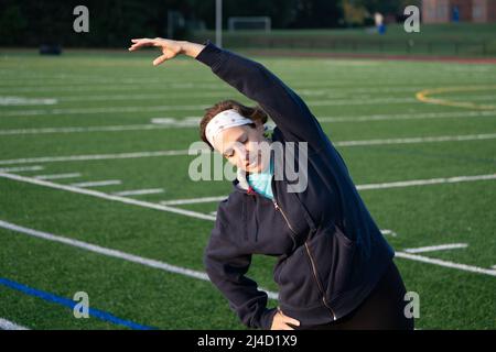 Am frühen Morgen Aufnahme einer Frau mittleren Alters bleiben fit durch Stretching und immer bereit zu trainieren. Aktives Lifestyle-Konzept. Stockfoto
