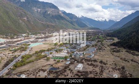 (220414) -- LHASA, 14. April 2022 (Xinhua) -- Luftfoto vom 12. April 2022 zeigt eine Ansicht eines Dorfes in der ethnischen Gemeinde Namyi Lhoba im Landkreis Mainling, südwestlich der Autonomen Region Tibet in China. Lhoba, eine ethnische Gruppe im Südosten Tibets, ist eine der kleinsten unter den 56 ethnischen Gruppen Chinas, was die Bevölkerung angeht. Die Lhoba haben ihre eigene gesprochene Sprache, aber keine schriftliche Form. Die Legende der Vorfahren von Lhoba wurde 2011 als nationales immaterielles Kulturerbe aufgeführt. (Xinhua/Jigme Dorje) Stockfoto