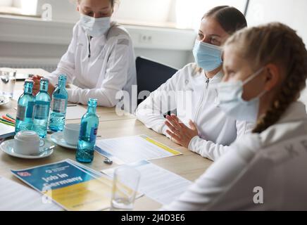 Köln, Deutschland. 14. April 2022. Frauen Flüchtlinge aus der Ukraine sitzen an einem Tisch während einer Beratungssitzung in einer Arbeitsberatung Zentrum am Hauptbahnhof. Die Deutsche Bahn und die Agentur für Arbeit haben gemeinsam in der Nähe der Bahnhöfe in Köln, Berlin und Frankfurt Arbeitsberatungsstellen für ukrainische Flüchtlinge eingerichtet. Quelle: Oliver Berg/dpa/Alamy Live News Stockfoto