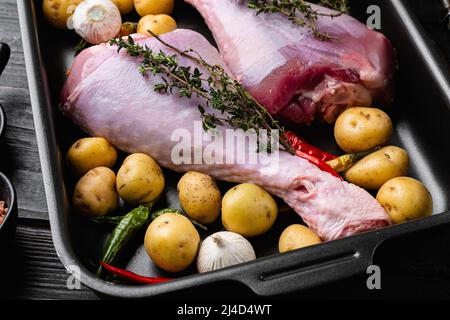 Frische putenbeine mit Zutaten für das Kochen Set, auf schwarzem Holztisch Hintergrund Stockfoto