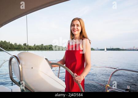 Eine stachelige Frau, die an einem sonnigen Sommertag am Fluss auf der Yacht posiert Stockfoto