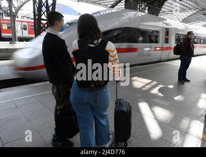 Köln, Deutschland. 14. April 2022. Reisende warten auf ihren Zug auf einem Bahnsteig am Hauptbahnhof. Kurz vor Karfreitag setzt die Deutsche Bahn weitere Züge ein, um den erwarteten Ansturm der Osterreisen besser zu bewältigen. Quelle: Roberto Pfeil/dpa/Alamy Live News Stockfoto