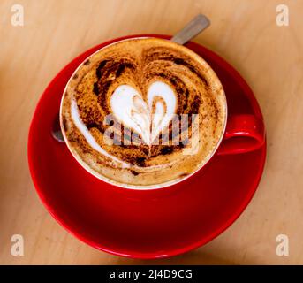 Cappuccino-Kaffeegetränk mit herzförmidem Schaum in einem Brighton Café in Großbritannien Stockfoto