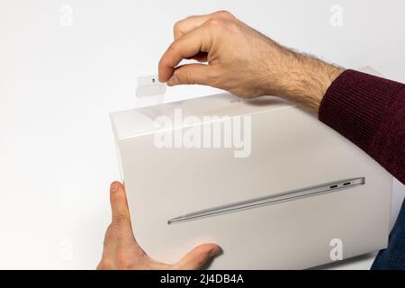 Saratov, Russland - 26. Februar 2022: Halten Sie Schutzfolie von Macbook Air 13 Zoll mit M1 Prozessor mit klebrigen Rand topview, weißer Hintergrund Stockfoto