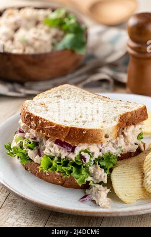 Thunfisch-Salat und Salat-Sandwich auf Vollkornbrot mit Kartoffelchips auf einem Teller Stockfoto